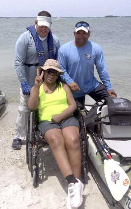 Disabled veteran Octavia Worrell being assisted into a kayak by Heroes on the Water volunteers Tim Stouder and Charlie Ganoe for her very first trip on the water at the Sebastian Inlet camping trip. (photo submitted)
