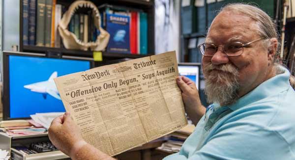 George Burgess, director of the Florida Program for Shark Research and International Shark Attack File at the University of Florida, displays newspaper coverage of the "12 Days of Terror," a series of five shark attacks in 1916 at the Jersey Shore that left four people dead and one wounded. (photo by Kristen Grace)