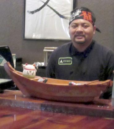 Al Chanthalack prepares to fill a sushi boat at Tomo's.